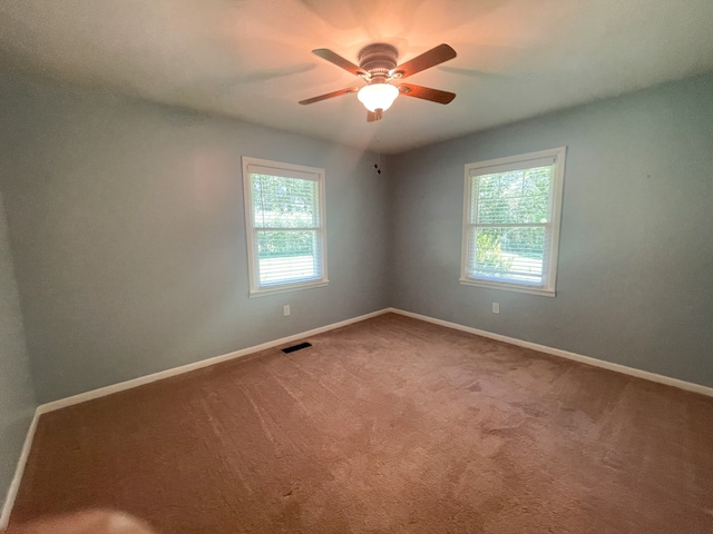 spare room with ceiling fan and carpet