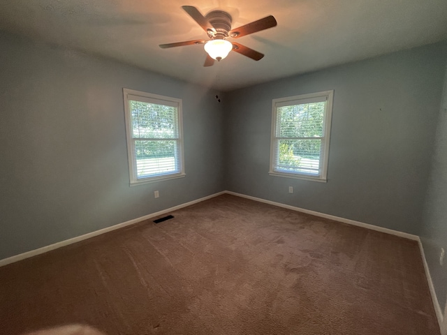 spare room with ceiling fan and carpet