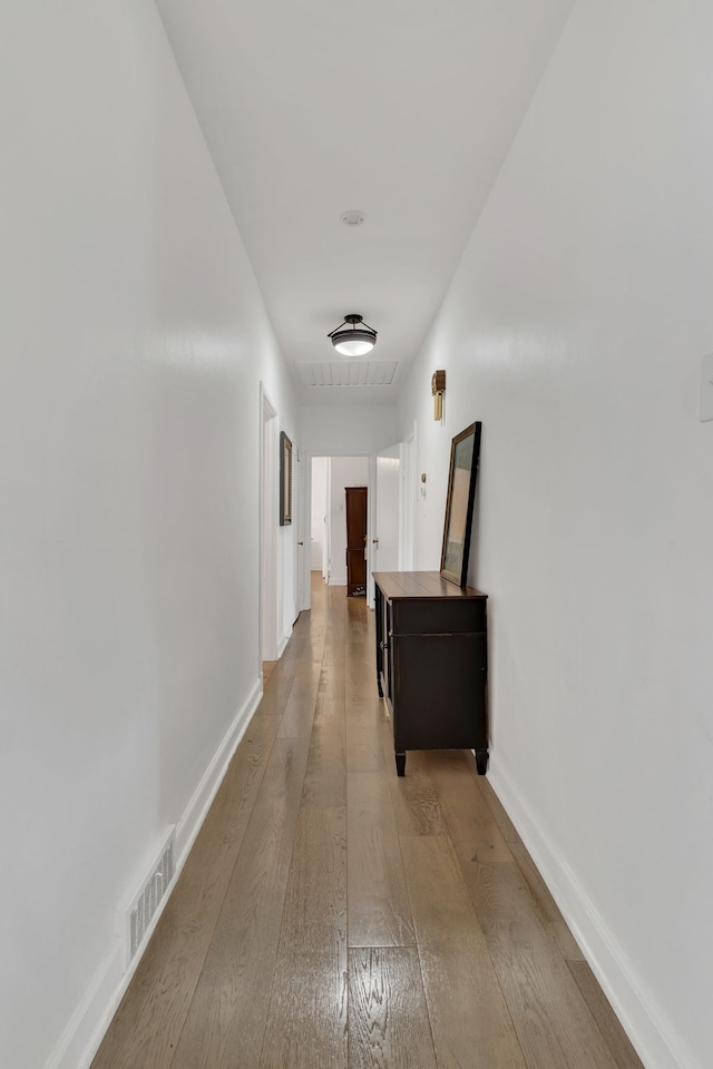 corridor with hardwood / wood-style flooring