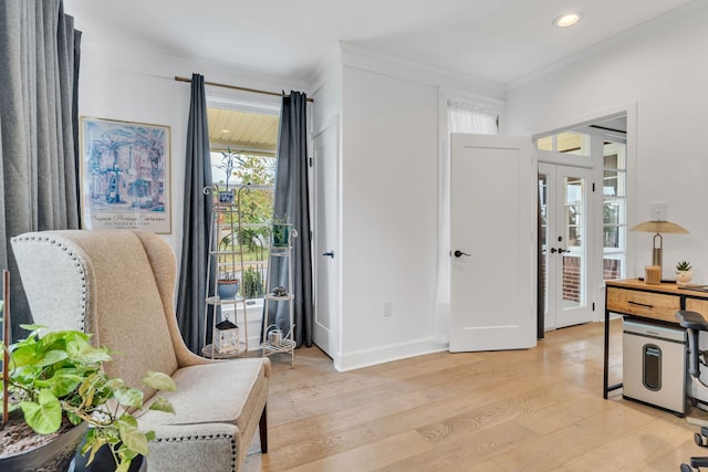 living area featuring ornamental molding, french doors, and light hardwood / wood-style flooring