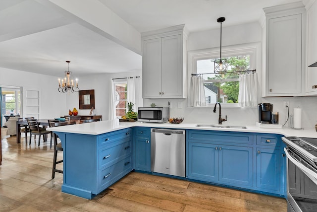 kitchen with blue cabinets, a notable chandelier, sink, white cabinets, and appliances with stainless steel finishes