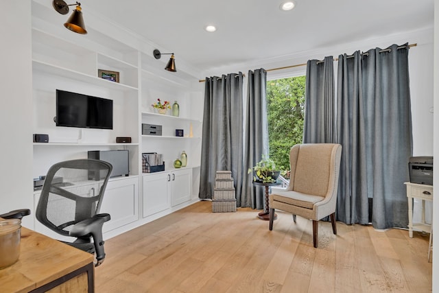 office space with built in shelves, light hardwood / wood-style flooring, and ornamental molding