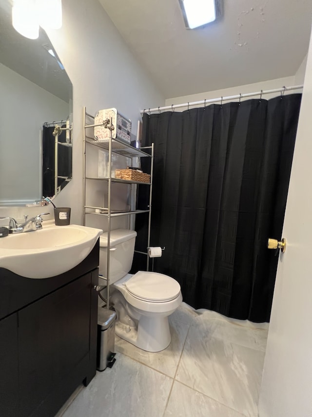 bathroom with vaulted ceiling, vanity, and toilet