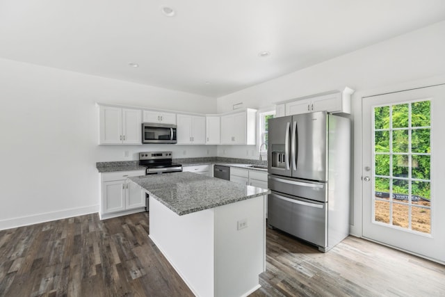 320 Moffat St Unit 103, Monteagle, TN 37356 - kitchen with appliances with stainless steel finishes, a kitchen island, light stone counters, white cabinets, and dark wood-style floors