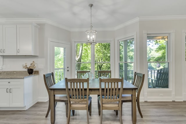 dining area featuring an inviting chandelier, light wood-type flooring, and crown molding