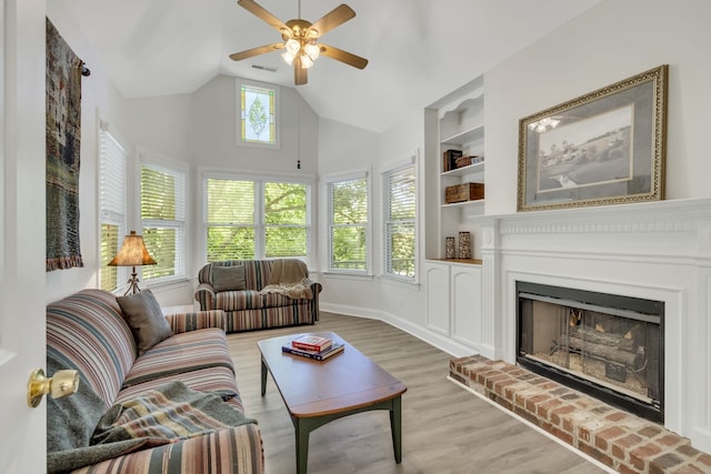 living room featuring wood-type flooring, high vaulted ceiling, a brick fireplace, ceiling fan, and built in features