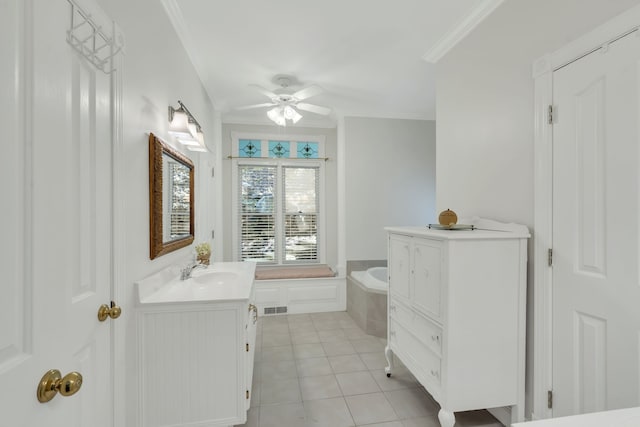 bathroom featuring ceiling fan, vanity, tiled tub, crown molding, and tile patterned flooring