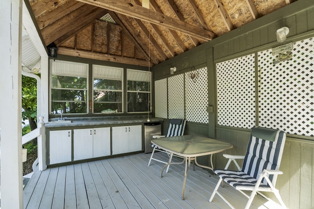 unfurnished sunroom with lofted ceiling with beams and sink