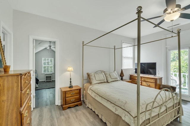 bedroom with lofted ceiling, light hardwood / wood-style floors, multiple windows, and ceiling fan