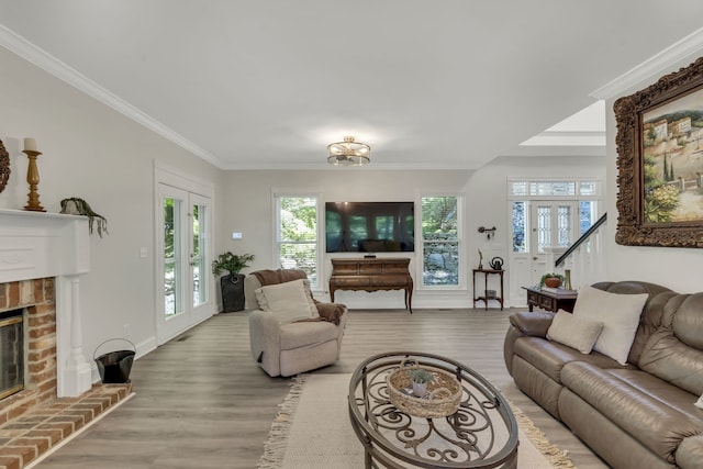 living room with ornamental molding, a brick fireplace, hardwood / wood-style flooring, and french doors