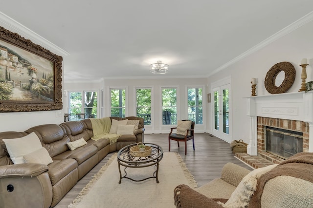 living room with wood-type flooring, a brick fireplace, and ornamental molding