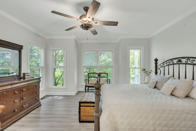 bedroom featuring ceiling fan, light hardwood / wood-style floors, and multiple windows