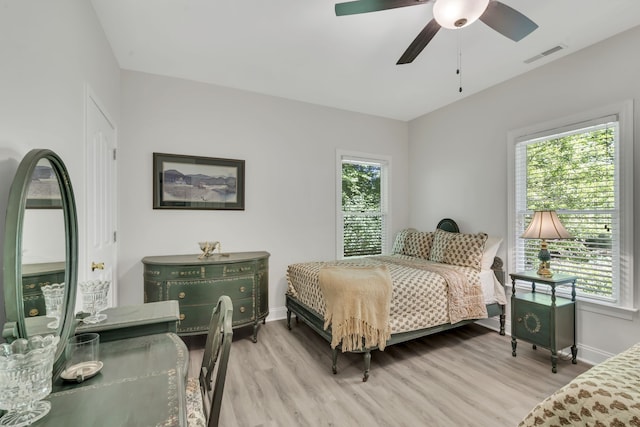 bedroom with multiple windows, ceiling fan, and light hardwood / wood-style flooring