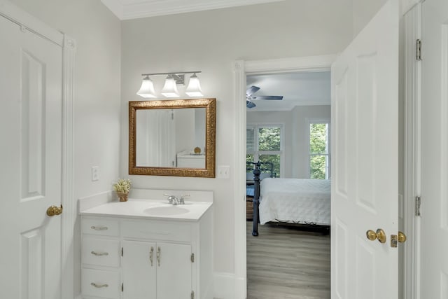 bathroom featuring ceiling fan, vanity, crown molding, and hardwood / wood-style floors