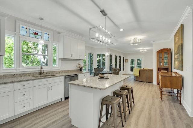 kitchen with white cabinets, stainless steel dishwasher, decorative light fixtures, and sink