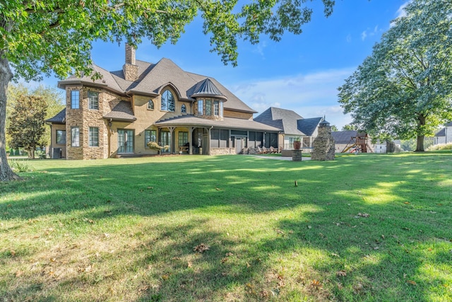 view of front of house with a playground, central AC, and a front yard