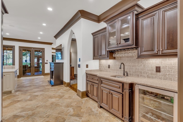 kitchen with beverage cooler, crown molding, sink, and decorative backsplash