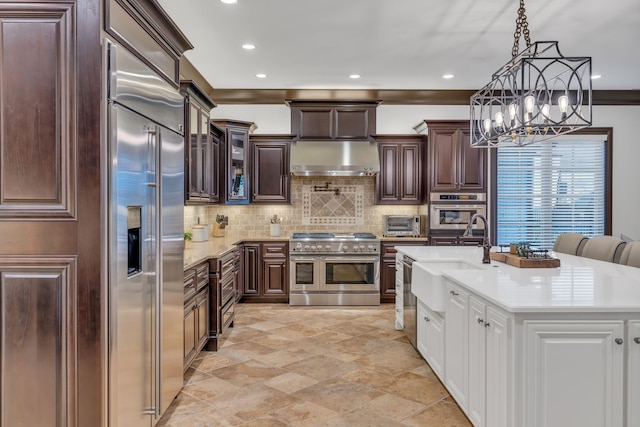 kitchen featuring dark brown cabinets, sink, backsplash, decorative light fixtures, and high quality appliances