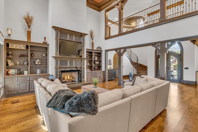 living room featuring light wood-type flooring and a high ceiling