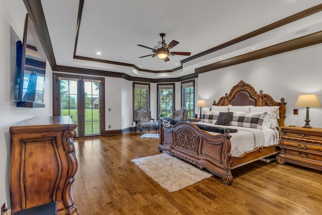 bedroom with access to exterior, crown molding, wood-type flooring, a tray ceiling, and ceiling fan