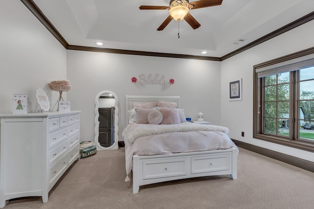 carpeted bedroom featuring ceiling fan, a tray ceiling, and ornamental molding