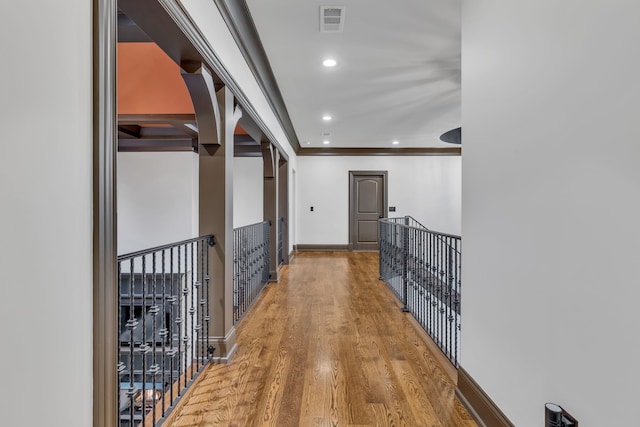 hallway featuring ornamental molding and hardwood / wood-style floors