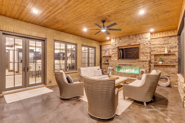 sitting room featuring french doors, a fireplace, ceiling fan, and wooden ceiling