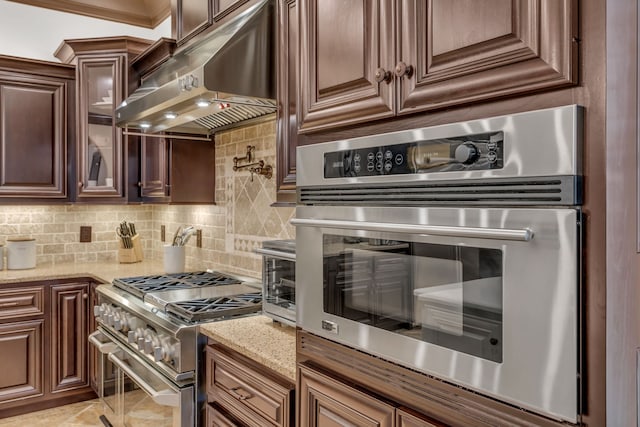 kitchen featuring light stone counters, stainless steel appliances, and tasteful backsplash