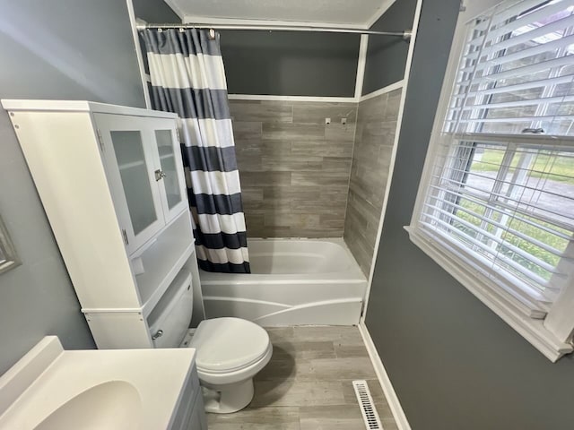 full bathroom featuring vanity, hardwood / wood-style floors, toilet, and shower / bathtub combination with curtain