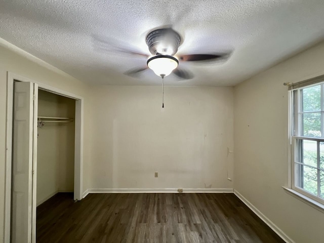 unfurnished bedroom featuring ceiling fan, a textured ceiling, a closet, and dark wood-type flooring