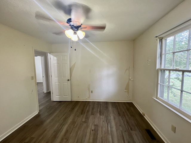 unfurnished room with ceiling fan, dark hardwood / wood-style flooring, and a wealth of natural light