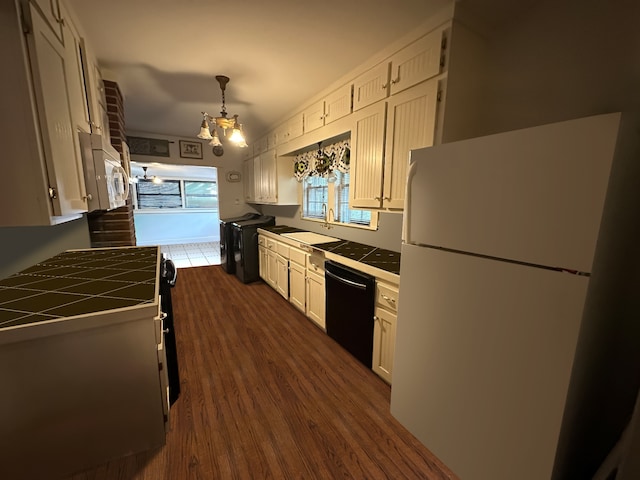 kitchen with dark wood-type flooring, white cabinets, white appliances, tile counters, and sink