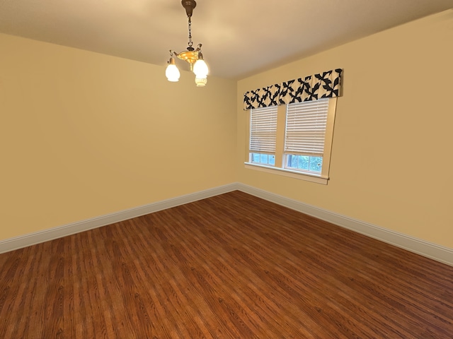 unfurnished room with hardwood / wood-style floors and a notable chandelier