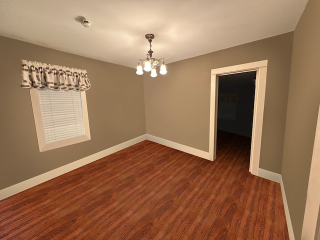 unfurnished room with an inviting chandelier and dark wood-type flooring