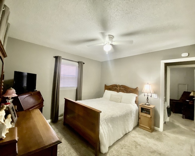 carpeted bedroom with ceiling fan and a textured ceiling