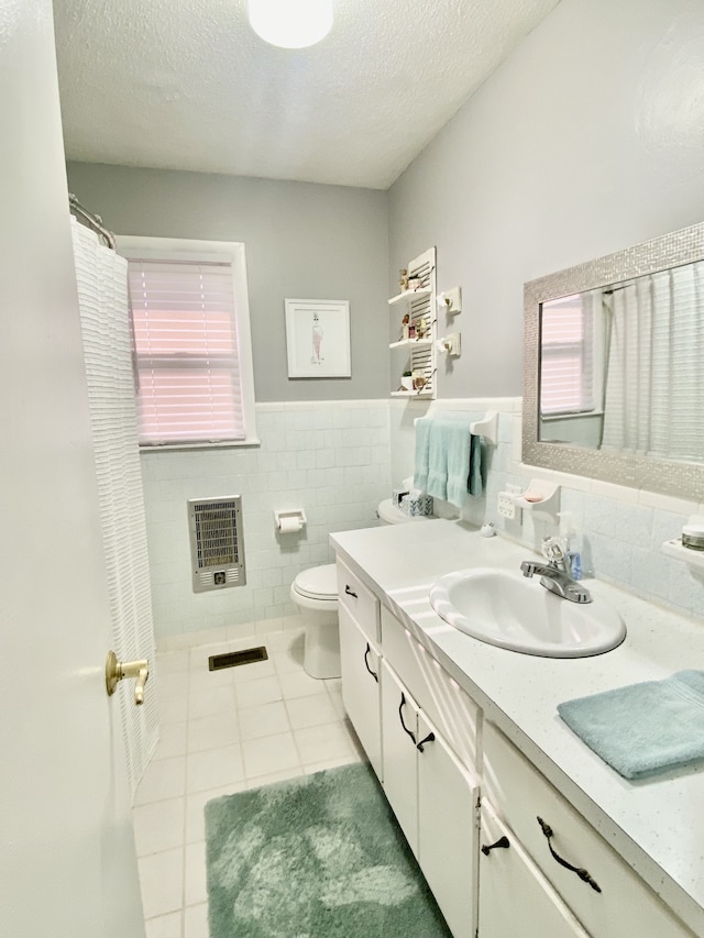 bathroom featuring vanity, heating unit, toilet, and a textured ceiling