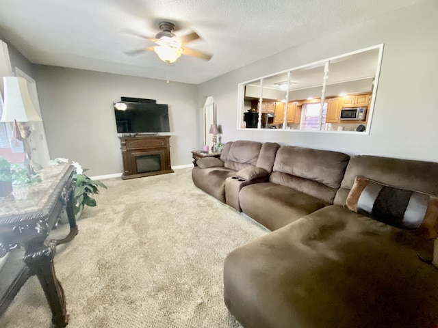 living room featuring a textured ceiling, carpet, ceiling fan, and plenty of natural light