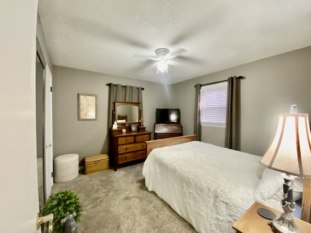 bedroom featuring a textured ceiling, light carpet, and ceiling fan