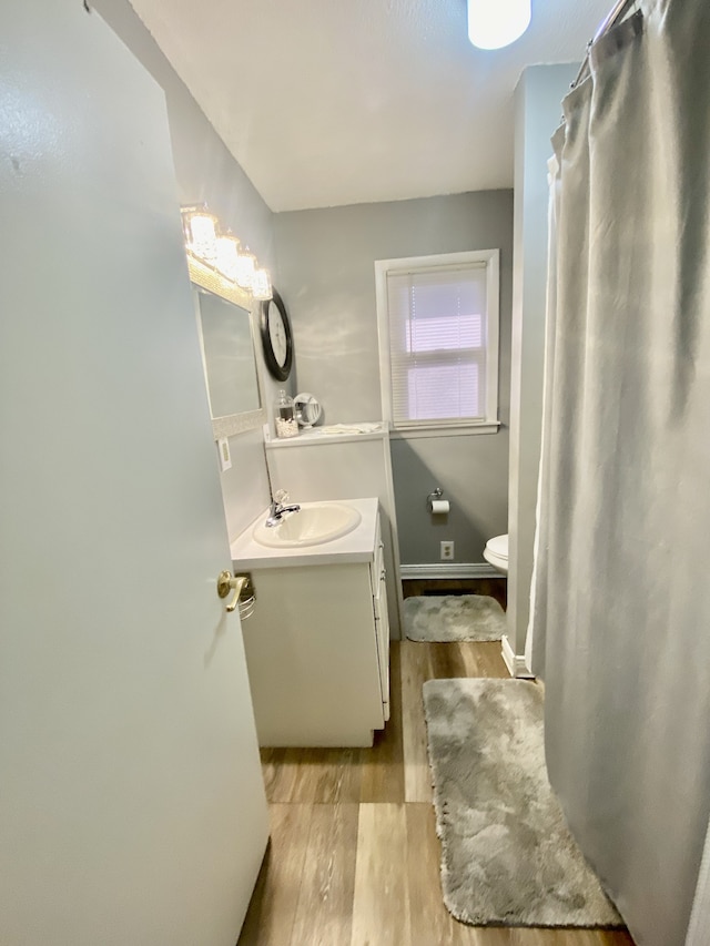 bathroom featuring vanity, toilet, and hardwood / wood-style flooring