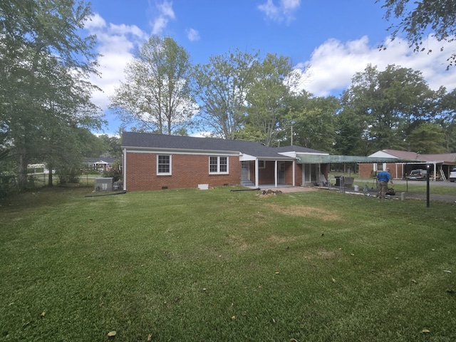 rear view of property featuring a lawn and a patio area