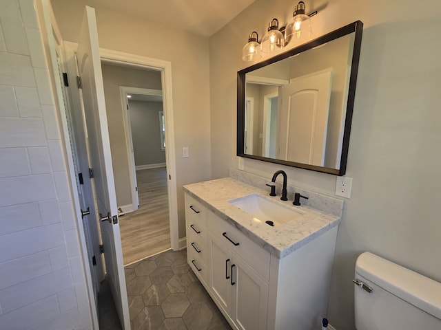 bathroom featuring wood-type flooring, vanity, and toilet