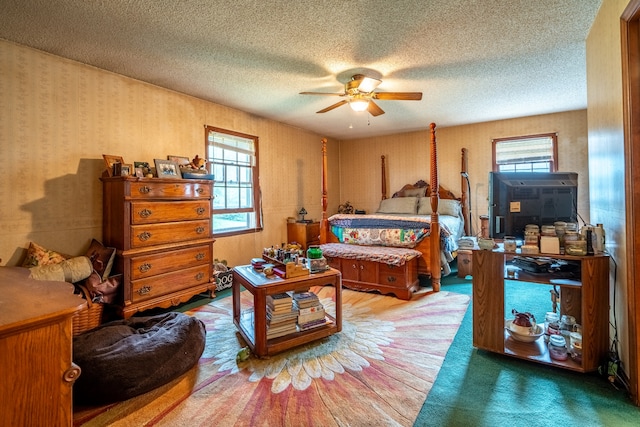 bedroom featuring ceiling fan, a textured ceiling, and carpet