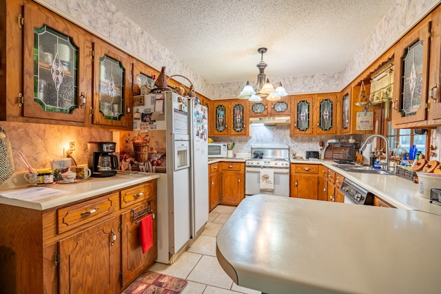 kitchen with pendant lighting, a notable chandelier, a textured ceiling, and white appliances