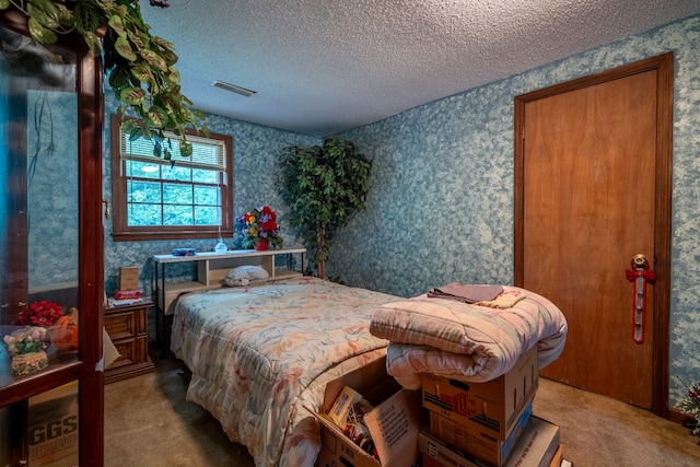 bedroom with a textured ceiling and light colored carpet