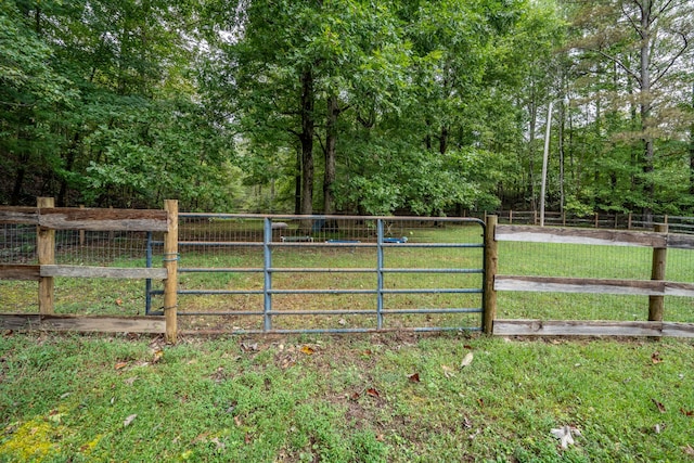 view of gate featuring a rural view and a yard