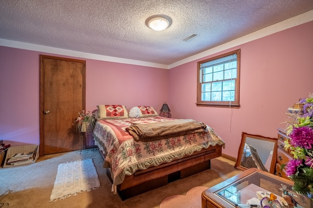 bedroom with light colored carpet and a textured ceiling