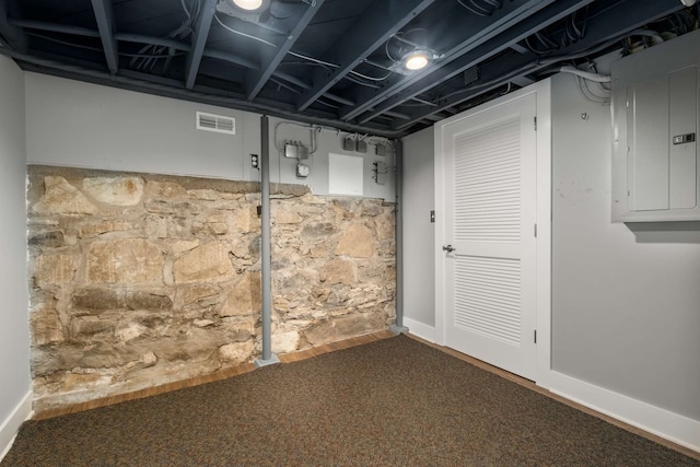 basement with carpet and electric panel