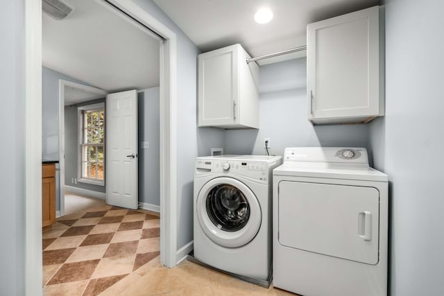 laundry room featuring cabinets and washer and clothes dryer