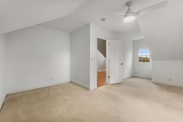 additional living space featuring light colored carpet, vaulted ceiling, and ceiling fan