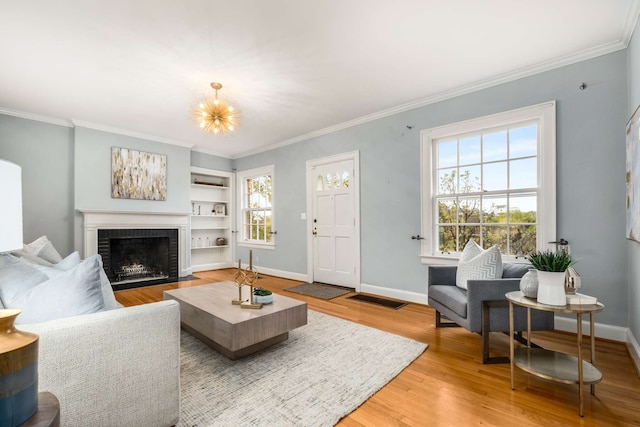 living room featuring hardwood / wood-style flooring, a healthy amount of sunlight, crown molding, and a brick fireplace